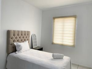 a white bedroom with a large bed and a window at Casa Coralina in San Carlos +1 photo