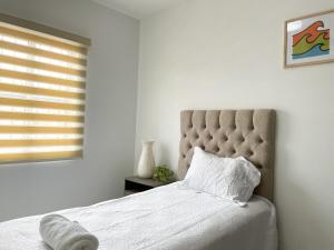 a bedroom with a bed with a pillow and a window at Casa Coralina in San Carlos
