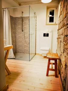 a glass shower in a room with a bench and a table at Lovingly Restored Half-Timbered House From 1684 in Großschönau