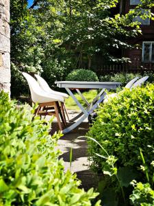 two chairs and a picnic table in a garden at Lovingly Restored Half-Timbered House From 1684 in Großschönau