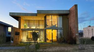 a house with glass doors and a brick building at Villa #40, Ambassadori Kachreti Golf Resort in Kachretʼi