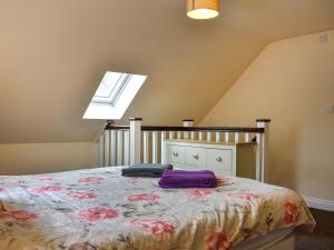 a bedroom with a bed with purple sheets and a window at Winnies Cottage in Belford