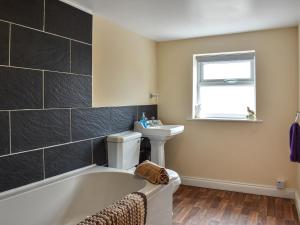 a bathroom with a bath tub and a sink at Winnies Cottage in Belford +1 photo