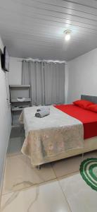 a bedroom with a large bed with a red blanket at Chalé canto do bugiu in Rio do Sul