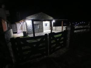 a house with a fence in front of it at night at Hospedaje Abiel in El Mollar +9 photos