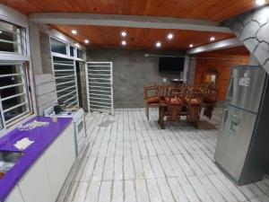 a kitchen and dining room with a table and a refrigerator at Hospedaje Abiel in El Mollar
