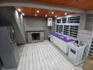 a kitchen with a stove and a fireplace at Hospedaje Abiel in El Mollar