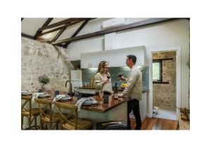 a man and a woman standing in a kitchen at Rústica Estate in Quindalup