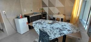 a small kitchen with a table and a refrigerator at Chalé canto do bugiu in Rio do Sul