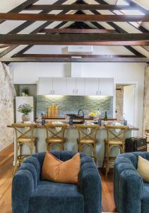 a living room with a blue couch and a kitchen at Rústica Estate in Quindalup