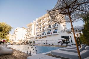 ein Hotel mit Schwimmbad neben einem Gebäude in der Unterkunft Chimaera Hotel in Himarë