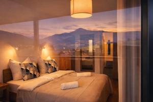 a bedroom with two beds in front of a window at Die Malerei Penthouse by Da Alois in Gröbming