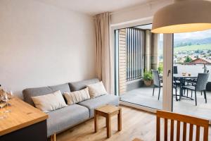 a living room with a couch and a table at Die Malerei Penthouse by Da Alois in Gröbming