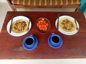 a table with three plates of food and two cups of coffee at Ekas Elen Homestay in Pulau Gilkaliantan +55 photos