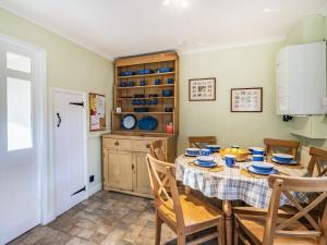 a dining room with a table and chairs and a refrigerator at 2 Fairview Terrace Ambleside in Ambleside
