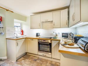 a kitchen with white cabinets and a sink at 2 Fairview Terrace Ambleside in Ambleside