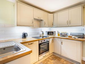 a kitchen with white cabinets and a sink at 2 Fairview Terrace Ambleside in Ambleside +13 photos