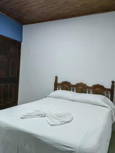a bedroom with a white bed with a wooden headboard at SJO - Casa Taccari in Grecia +18 photos