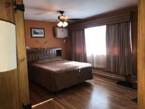 a bedroom with a bed and a ceiling fan at Trout Town Inn in Roscoe