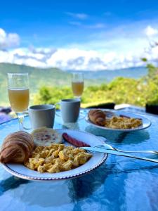 a table with two plates of food and glasses of beer at Arrayán Glamping Villa 2 in San Gil