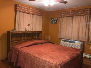 a bedroom with a large bed and a fan at Trout Town Inn in Roscoe +20 photos