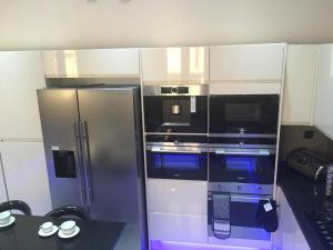 a kitchen with a stainless steel refrigerator and a table at Gazalle Oasis in El Biar
