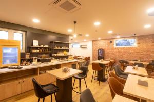a restaurant with tables and chairs and a brick wall at Campanile Grenoble Centre Gare in Grenoble