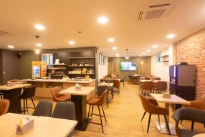 a restaurant with tables and chairs and a kitchen at Campanile Grenoble Centre Gare in Grenoble