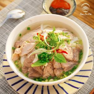 a bowl of soup with meat and vegetables on a table at La Mer Boutique House in Cù Lao Thu