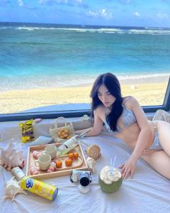 a woman in a bikini laying on a beach at La Mer Boutique House in Cù Lao Thu