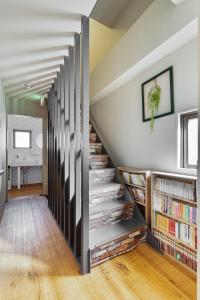 a staircase with bookshelves in a living room with a book shelf at Guesthouse YOURS in Osaka