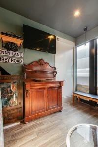 a room with a large wooden entertainment center with a flat screen tv at Guesthouse YOURS in Osaka +22 photos