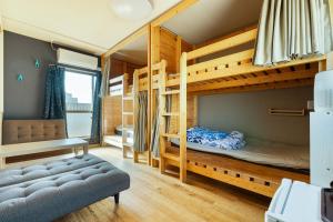 a bedroom with a bunk bed and a couch at Guesthouse YOURS in Osaka