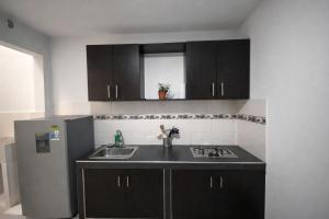 a kitchen with a sink and a refrigerator at Inmosolaris in Cali