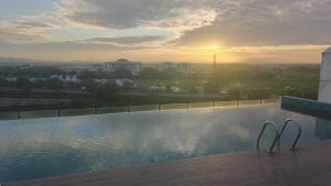 a swimming pool with the sunset in the background at Alor Setar Imperio Studio by IM Staycation in Alor Setar +7 photos