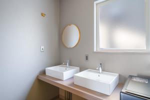 a bathroom with two white sinks and a mirror at The Crane Sanctuary Kamifurano in Kami-furano