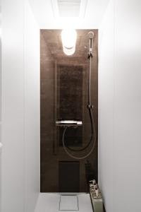 a bathroom with a shower with a light on the wall at The Crane Sanctuary Kamifurano in Kami-furano +104 photos