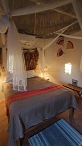 a bedroom with a large bed with a canopy at Cabaña 2 Los Gallitos Ecolodge in Sacalum