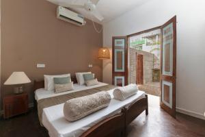 a bedroom with two beds and a window at Villa Monsoon in Mount Lavinia