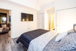 a bedroom with a bed and a tv on the wall at Penthouse Retreat with Rooftop Pool Explore Silver Spring & Washington DC in Silver Spring +21 photos