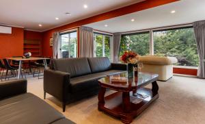 a living room with a couch and a table at Hana Lodge in Rotorua