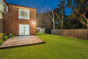 a backyard with a brick house with a lawn at Forest view guesthouse in Runcorn