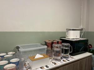 a kitchen counter with a coffee maker and other items at Nitra Hostel Siriraj in Bangkok
