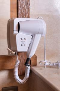 a white phone is hanging on a wall at Kirani House - Joglo Villa Bali in Darmasaba