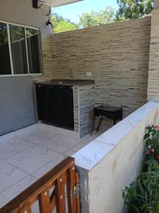 a patio with a large screen tv on a brick wall at Kitnet na mata atlantica in Ubatuba +20 photos