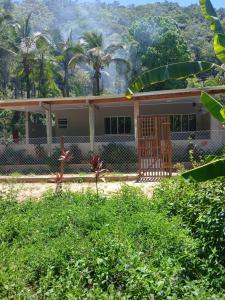 a house with a fence in front of it at Kitnet na mata atlantica in Ubatuba
