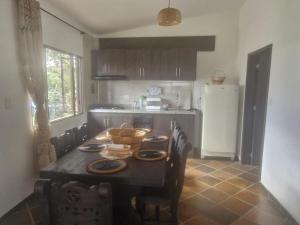 a kitchen with a table with chairs and a refrigerator at Villa Alejandra in Quebrada Vieja