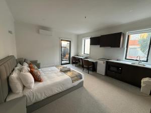 a bedroom with a bed and a kitchen with a sink at Sixty Two On Grey Serviced Apartments in Melbourne