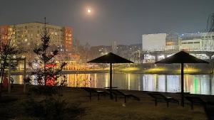 a group of chairs and umbrellas by a river at night at Двухместная комната общая ванная, Double Room Shared Bathroom in Chişinău
