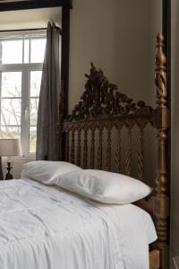 a bed with a wooden head board and a window at Vista Verde Retreat in Bretanha +50 photos